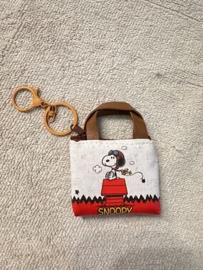 Snoopy keychain mini zipper purse with Snoopy sitting on a red doghouse